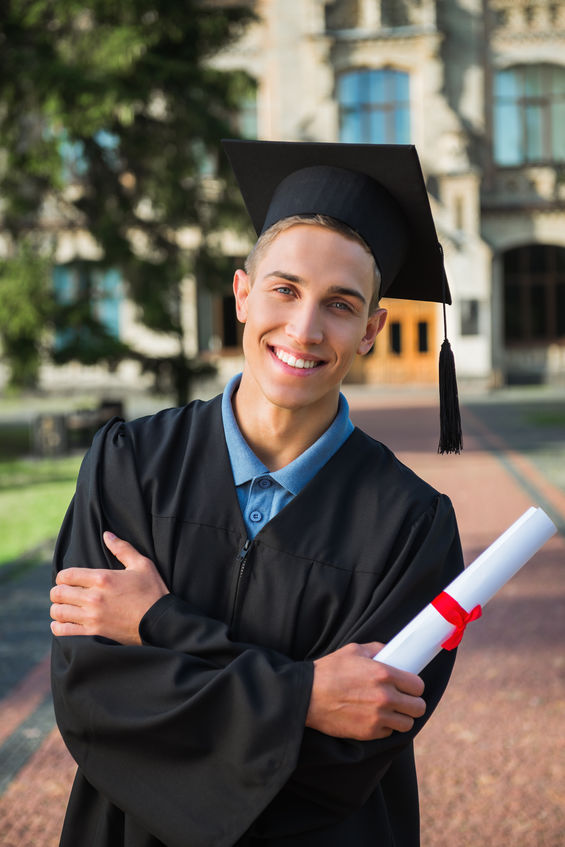 Young male student who just graduated holding his diploma